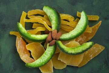 composition of candied mango, melon, papaya, pomelo on a green background