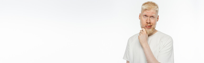 pensive albino man in t-shirt touching beard while thinking on white, banner - obrazy, fototapety, plakaty