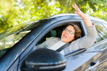 Furious stressed woman screaming while driving