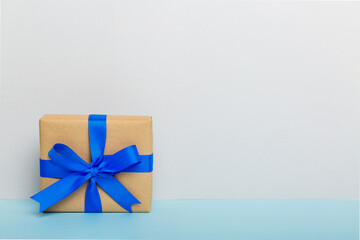 holiday handmade paper present tied blue ribbon bow top view with copy space. Flat lay holiday background. Birthday or christmas present. Christmas gift box concept with copy space