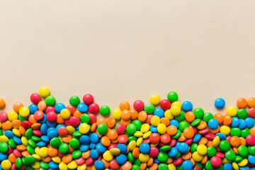 Mixed collection of colorful candy, on colored background. Flat lay, top view. frame of colorful chocolate coated candy