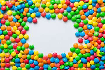 Mixed collection of colorful candy, on colored background. Flat lay, top view. frame of colorful chocolate coated candy