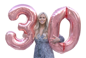 Attractive woman celebrating her 30th birthday holding two large pink, numeral balloons 3 and 0. PNG.