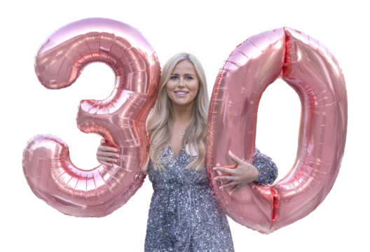Attractive woman celebrating her 30th birthday holding two large pink, numeral balloons 3 and 0. PNG.