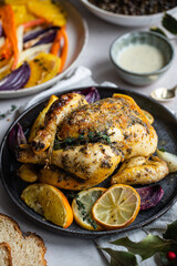 Dinner with oven baked spring chicken (coquelet jaune) in French herbs and citruses, baked vegetables and lentils on white background.