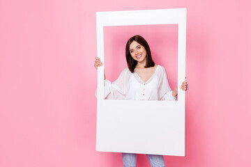 Photo of sweet adorable lady hand hold white picture dressed trendy clothes stand empty space isolated on pink color background © deagreez