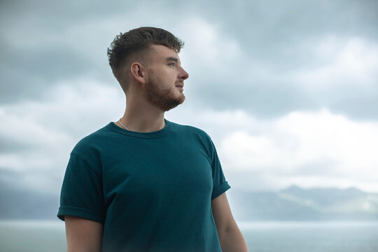 Profile Side Photo Of Handsome Happy Guy, Young Man Enjoying Sea, Ocean View, Landscape, Looking Into Distance At Summer Day In Tropical Country At Storm With Cloudy Sky, Breathing Deep Fresh Air