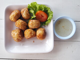 Large fried crab meat (Hoi-jo) served on rectangular dish with plum sauce and coriander. Crab Jujube is traditional Chinese food and popular appetizer. Ingredients: crab lard, water chestnuts
