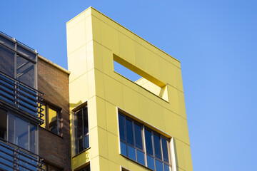Multi-apartment high-rise residential panel building against the blue sky background. Modern urban architecture.