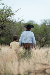 Gaucha life, a father and son walking through the Argentine steppe