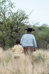 Gaucha life, a father and son walking through the Argentine steppe