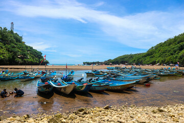 Yogyakarta, Indonesia in October 2022. Local tourists enjoying Baron beach, Gunung Kidul with boat.