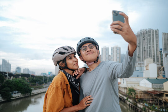 A young couple taking pictures with their mobile phones.