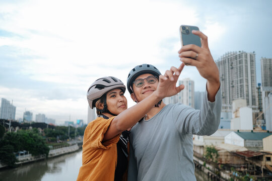 A young couple taking pictures with their mobile phones.