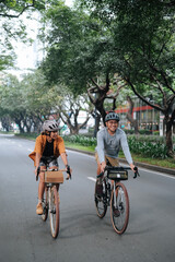 A young couple riding their bikes together in the city.