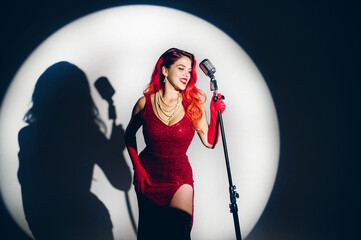 Gorgeous red haired woman with retro microphone singing on stage