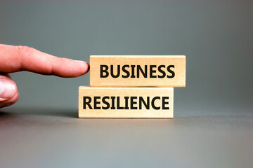 Business resilience symbol. Concept word Business resilience typed on wooden blocks. Beautiful grey table grey background. Businessman hand. Business and business resilience concept. Copy space.
