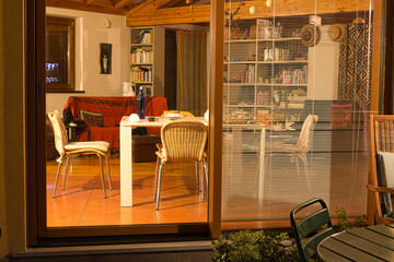 View from a large window of an illuminated interior on a winter night.