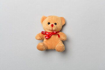 Cute teddy bear on color background, top view