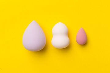 Beauty blenders on color background, top view