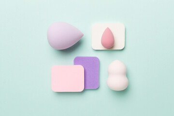Beauty blenders on color background, top view