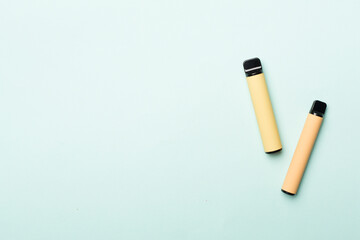Disposable electronic cigarettes on color background, top view