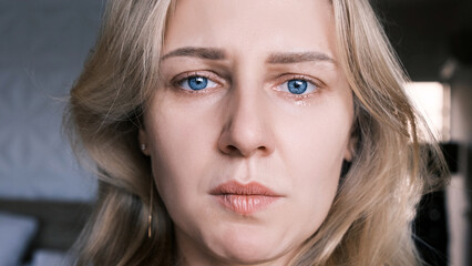 Portrait of crying grieving woman of 30 years. Grimace of sadness with tears in her eyes and...