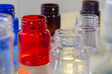 Medical empty colorful glass bottles in showcase at pharmaceutical exhibition, pharmacy laboratory. Pharma industry, science, medicine, experiment and healthcare concept