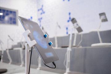 Close up view: many floor mount tablets at science exhibition, museum, auditorium or classroom - nobody, no people. Technology, futuristic, education concept.