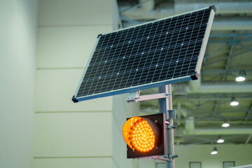 Single signal LED orange traffic light powered by solar panels installed above at transport...
