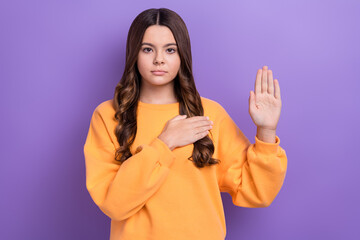 Portrait of lovely serious girl arm touch heart chest raise palm swear isolated on purple color background