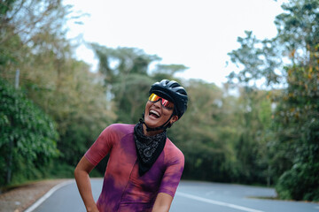 A young woman cyclist happily laughing.