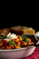Baked ziti pasta with Italian sausage and marinara sauce. Garnished with parsley and shaved parmesan cheese.