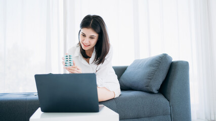 Woman engages in a videoconference with a doctor through her smartphone while at home in isolation under hospital quarantine.