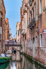 narrow canal in Venice with historic houses and a gate to enter the canal, Venice,