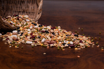 cesto di vimini con legumi e cereali su un tavolo di legno