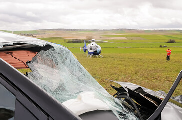 Emergency helicopter about to transfer a traffic accident victim on a very windy day in a rural...