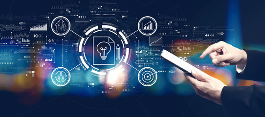 Idea of success theme with businessman using a tablet computer at night