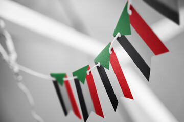 A garland of Sudan national flags on an abstract blurred background