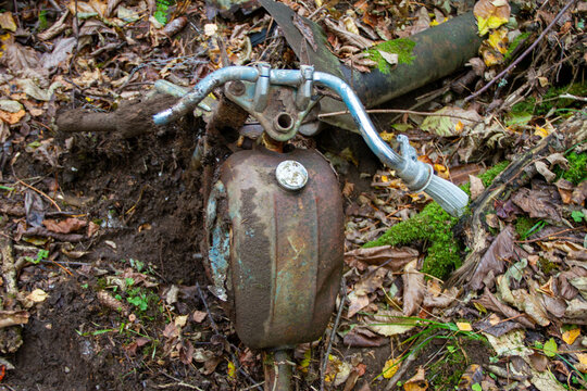 Rusty abandoned moped in forest