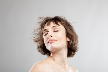 studio portrait of a beautiful brunette girl with short hair in the air