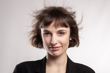 studio portrait of a beautiful brunette girl with short hair in the air