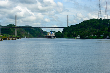 Freighter and tugboat approaching Centennial bridge near Pedro Miguel locks on the Panama canal.