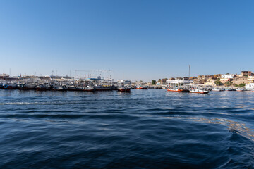 Fototapeta premium River Nile full of boats that take tourists to the Philae temple in the city of Aswan, on a sunny day.