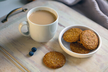 White cup of coffee with amaretti on light gray background with wooden table. aroma espresso mug