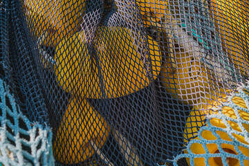 Fishing net with yellow floats dries on the pier, close-up, selective focus. concepts of fishing in coastal towns