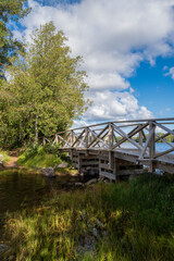 Fototapeta na wymiar Summer view of Liesjarvi National Park, wooden bridge and lake, Tammela, Finland