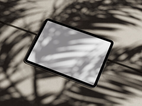 tablet with white screen to put text with shadow of palm tree leaves
