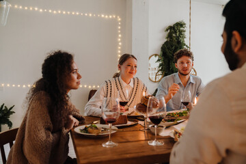 Group of friends talking while having traditional Christmas dinner
