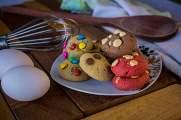 biscuit, biscuit, chocolate, with chocolate drops, traditional, cream, milk, chocolate, and with toppings, a delight with coffee made in an artisan way, set on a rustic wooden table.